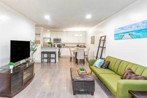 sala de estar con sofá verde y cocina en Condo in Most sought after neighborhoods en Oakland
