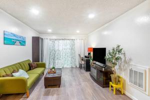 sala de estar con sofá verde y TV en Condo in Most sought after neighborhoods, en Oakland