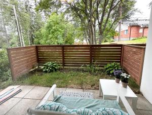 a backyard with a wooden fence and a table at Spacious and modern apartment in Mikkeli