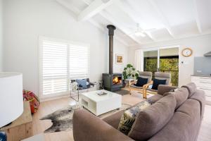 Una sala de estar con un sofá y una chimenea. en Mariners Retreat Jervis Bay, en Vincentia