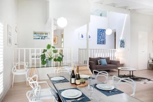 Una sala de estar blanca con una mesa y sillas. en Mariners Retreat Jervis Bay, en Vincentia