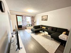 a living room with a couch and a tv at Spacious and modern apartment in Mikkeli