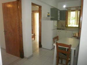 a kitchen with a table and a refrigerator at Giannis Studios in Nikiana