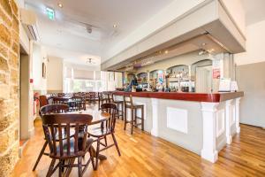a bar in a restaurant with wooden tables and chairs at The Morar Hotel in Morar