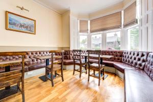 a restaurant with leather seats and tables and windows at The Morar Hotel in Morar