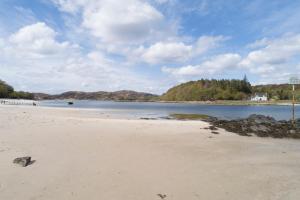 a sandy beach with a view of a body of water at The Morar Hotel in Morar