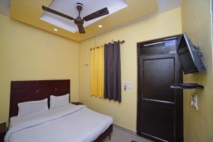 a bedroom with a bed with a ceiling fan and a television at Hotel Rama Palace in Morādābād