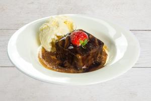 a plate of chocolate dessert with a strawberry and ice cream at The Morar Hotel in Morar