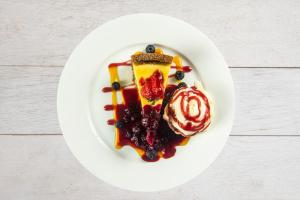 a white plate with a dessert with berries and sauce at The Morar Hotel in Morar