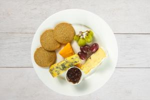 a plate of food with cheese and fruit on it at The Morar Hotel in Morar