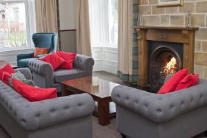 a living room with two chairs and a fireplace at The Morar Hotel in Morar