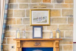 a stone wall with a table with a picture on it at The Morar Hotel in Morar