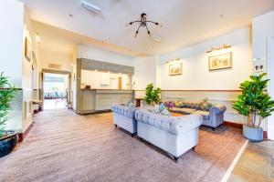 a living room with two couches and a kitchen at The Morar Hotel in Morar