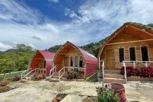 twee huizen met rode daken voor een berg bij Penginapan puncak Dua Mitra RedDoorz in Berastagi