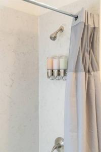 La salle de bains est pourvue d'un rideau de douche et d'un lavabo. dans l'établissement Modern Cottage near many conveniences, à Oakland
