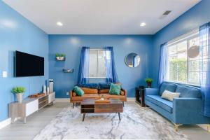 a blue living room with a couch and a tv at Modern Cottage near many conveniences in Oakland