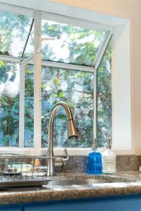 a kitchen sink with a window above a kitchen counter at Modern Cottage near many conveniences in Oakland