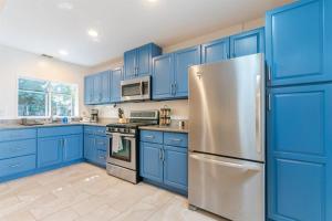a kitchen with blue cabinets and a stainless steel refrigerator at Modern Cottage near many conveniences in Oakland