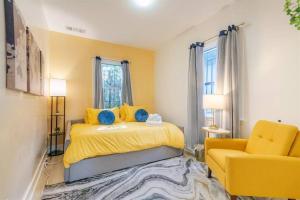 a bedroom with a yellow bed and a yellow chair at Modern Cottage near many conveniences in Oakland
