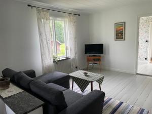 sala de estar con sofá y TV en Villa Walterängen, en Tibro