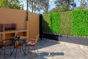 a privacy fence with a table and chairs on a patio at Hip Casa Beatles in downtown Gated Parking in Ensenada