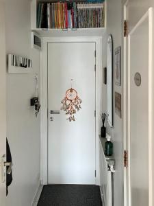 Un pasillo con una puerta blanca con un reloj. en Duinster Heist beach, en Knokke-Heist