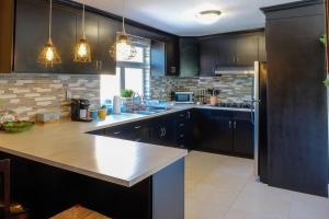 a kitchen with black cabinets and a white counter top at Hip Casa Beatles in downtown Gated Parking in Ensenada