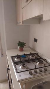- une cuisine blanche équipée de plaques de cuisson dans l'établissement Casetta Cavour, à Pantelleria