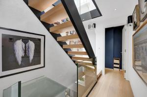 un escalier dans une maison avec des ailes d'ange sur le mur dans l'établissement Luxury 3 Bed House by Hyde Park, Bayswater, à Londres