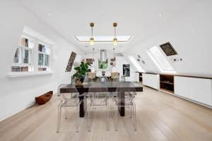 a dining room with a glass table and chairs at Luxury 3 Bed House by Hyde Park, Bayswater in London