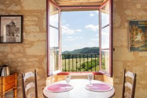 una mesa con 2 sillas y una ventana con vistas en Tour Pissarro, en Beynac-et-Cazenac 11 fotos más