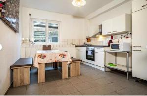 a kitchen with a table and a stove and a microwave at 2 Zimmerwohnung in 88099 Neukirch ab 2 Übernachtungen in Neukirch