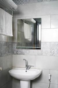 Baño blanco con lavabo y espejo en flamingo hotel irbid, en Zabdah