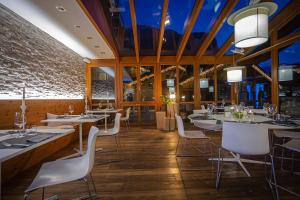 a restaurant with white tables and white chairs at Hotel B&B Andreas in Canazei