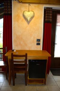 a wooden table with two chairs and a heart on the wall at Arthemisia in Rhêmes-Notre-Dame