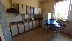 a kitchen with white cabinets and a blue table at Willa Rybitwa in Gdynia