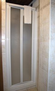 a glass shower door in a bathroom with a towel at Arthemisia in Rhêmes-Notre-Dame