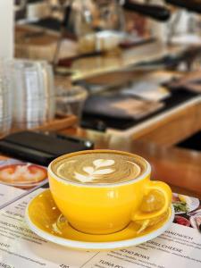 a yellow cup of coffee on a plate on a table at Haadson Resort & Koh Raham in Haad Son