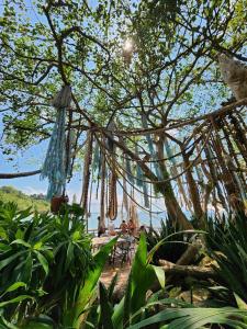 a group of people sitting on a beach under a tree at Haadson Resort & Koh Raham in Haad Son