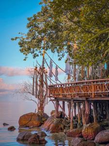 a bridge over the water with people standing on it at Haadson Resort & Koh Raham in Haad Son