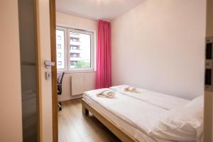 a small bedroom with a bed and a window at Apartament Strefa Czasu in Toruń