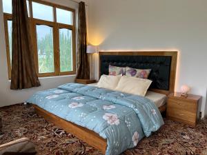 a bedroom with a large bed with a large window at Nature Palace Farmstay in Shey
