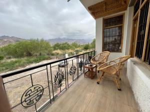 a balcony with chairs and a view of the mountains at Nature Palace Farmstay in Shey