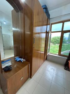 a bathroom with a wooden cabinet and a mirror at Nature Palace Farmstay in Shey