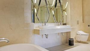 a bathroom with two sinks and a mirror at Goodrich Suites, Jakarta in Jakarta