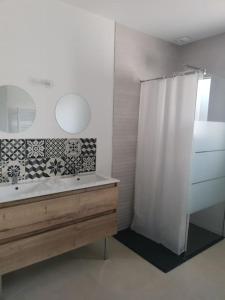 ein Bad mit einer Dusche, einem Waschbecken und einem Spiegel in der Unterkunft Maison neuve à 2 pas des plus belles plages de Douarnenez - Classé Meublé de Tourisme 3 étoiles in Kerlaz