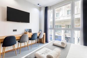 a room with a desk and chairs and a large window at NALU Valencia Boutique Rooms in Valencia