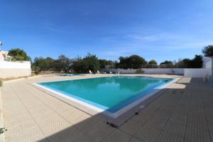 a swimming pool with blue water in a yard at Villa Lídia in Armação de Pêra