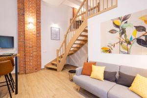 - un salon avec un canapé et un escalier dans l'établissement FeelgooD Apartments LOFT Zwickau CityCenter mit TG-Stellplatz, Netflix, Waipu-TV und Klima, à Zwickau