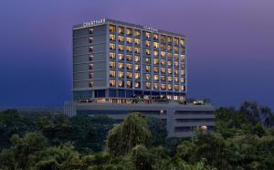 un edificio de hotel con sus luces encendidas en Courtyard by Marriott Ahmedabad Sindhu Bhavan Road en Ahmedabad